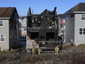 Firefighters investigate following a house fire in the Spryfield community in Halifax on Tuesday, February 19, 2019. Dozens of people gathered outside the charred remnants of a suburban Halifax home Tuesday night to mourn the loss of seven children killed in a fast-moving fire and to show support for the injured, grieving parents left behind.