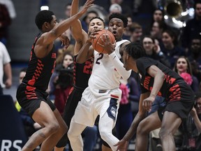 Connecticut's Tarin Smith, center, is pressured by Houston's Corey Davis Jr. , left, Galen Robinson Jr. back center, and DeJon Jarreau, right, during the first half of an NCAA college basketball game, Thursday, Feb. 14, 2019, in Hartford, Conn.