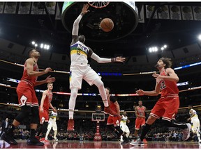 New Orleans Pelicans forward Cheick Diallo (13) dunks the ball as Chicago Bulls center Robin Lopez (42) and guard Timothy Luwawu-Cabarrot, left stand nearby during the first half of an NBA basketball game Wednesday, Feb. 6, 2019, in Chicago.