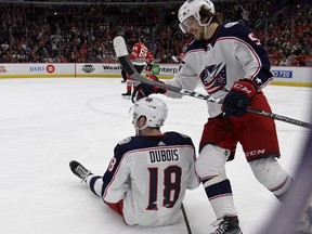 Columbus Blue Jackets center Pierre-Luc Dubois (18) gets a pat on the head from left wing Artemi Panarin (9) after he fell to the ice following a goal against the Chicago Blackhawks during the first period of an NHL hockey game Saturday, Feb. 16, 2019, in Chicago.