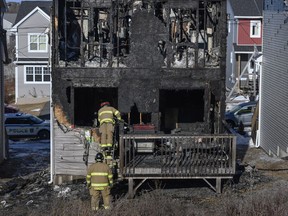 Firefighters investigate following a house fire in the Spryfield community in Halifax on Tuesday, February 19, 2019. Halifax police say they have responded to a fatal fire in the city, although there are no details on how many people are victims. Police say firefighters were called to a home on Quartz Drive in Spryfield around 1 a.m. today.