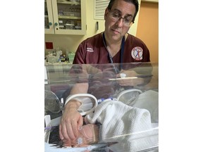 Doctor Timothy Hardcastle treats a baby in hospital after she was rescued from a storm water pipe in Durban, South Africa, Monday, Feb. 11, 2019. The newborn, believed to be between one and three days old, was rescued after a three-hour rescue mission. (AP Photo)