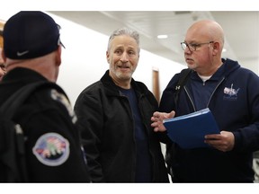 Entertainer and activist Jon Stewart, center, speaks with members of the FealGood Foundation as they arrive on Capitol Hill to speak with lawmakers about the compensation fund for victims of 9/11, Monday, Feb. 25, 2019, on Capitol Hill in Washington. Stewart has been involved in urging support for the first responders, volunteers, and survivors of the September 11 attacks.