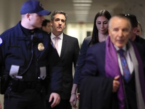 Michael Cohen, President Donald Trump's former lawyer, back center, leaves after a closed door Senate Intelligence Committee hearing on Capitol Hill in Washington, Tuesday, Feb. 26, 2019.
