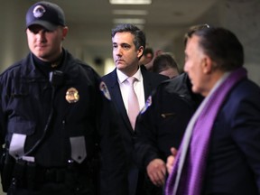 Michael Cohen, President Donald Trump's former lawyer, center, leaves after a closed door Senate Intelligence Committee hearing on Capitol Hill in Washington, Tuesday, Feb. 26, 2019.