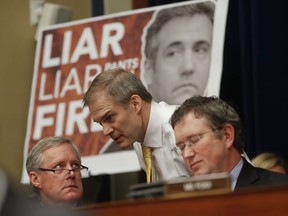 Rep. Jim Jordan, R-Ohio, center, ranking member of the Committee on Oversight and Reform talks with Rep. Mark Meadows, R-N.C., left, and Rep. Thomas Massie, R-Ky., right, during testimony by Michael Cohen, President Donald Trump's former personal lawyer on Capitol Hill in Washington, Wednesday, Feb. 27, 2019.