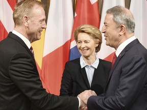 German minster of Defense Ursula von der Leyen, center, smiles when United States Secretary of Defense Patrick Shanahan, left, shakes hands with the Turkish minster of Defense Hulusi Akar, right, during the International Security Conference in Munich, Germany, Friday, Feb. 15, 2019.