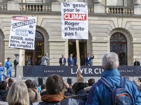 People demonstrate for climate in front of team Europe's Laver Cup captain Bjorn Borg, back 2nd left, and Switzerland's Roger Federer, right, who greet their supporters, in Geneva, Switzerland, Friday, Feb. 8, 2019. Protesters display a sign reading "Action for climate, Roger don't hesitate".