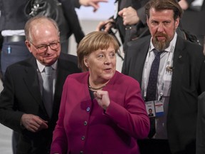 German Chancellor Angele Merkel, center, arrives for a meeting during the Munich Security Conference in Munich, Germany, Saturday, Feb. 16, 2019.