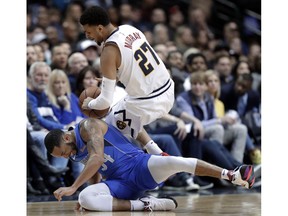 Dallas Mavericks guard Devin Harris (34) trips Denver Nuggets guard Jamal Murray (27) as the two chased a loose ball during the first half of an NBA basketball game in Dallas, Friday, Feb. 22, 2019.