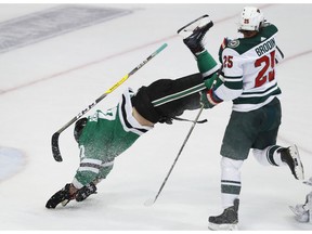 Dallas Stars right wing Alexander Radulov (47) is knocked off his feet by Minnesota Wild defenseman Jonas Brodin (25) during the first period of an NHL hockey game in Dallas, Friday, Feb. 1, 2019.