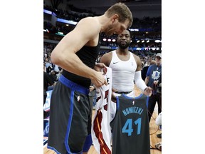 Dallas Mavericks' Dirk Nowitzki left, and Miami Heat's Dwyane Wade, second from right, talk as they swap jerseys after an NBA basketball game in Dallas, Wednesday, Feb. 13, 2019.