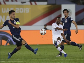 Qatar's midfielder Abdelaziz Hatem scores his team's second goal between Japan's Maya Yoshida , left, and Hidemasa Morita during the AFC Asian Cup final match between Japan and Qatar in Zayed Sport City in Abu Dhabi, United Arab Emirates, Friday, Feb. 1, 2019.