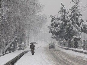 A Kashmiri man walks on a snow covered road after fresh snowfall on the outskirts of Srinagar, Indian controlled Kashmir, Thursday, Feb. 7, 2019. The fresh snowfall has resulted in disruption of air and road traffic for the second consecutive day between Srinagar and Jammu, the summer and winter capitals of India's troubled state.