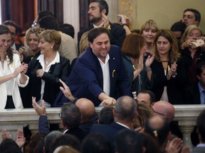 FILE - In this Friday, Oct. 27, 2017 file photo, Catalan Vice President Oriol Junqueras, center, is greeted after a vote on independence in the Catalan parliament in Barcelona, Spain. Spain's Supreme Court is bracing to hold the nation's most sensitive trial in four decades of democracy this week with all eyes focused on its ability to stand up to concerted campaign by Catalonia's separatists to attack its credibility. Twelve high-profile Catalan separatists will face charges including rebellion for their role in a failed attempt to achieve secession for the prosperous north-eastern region in 2017.