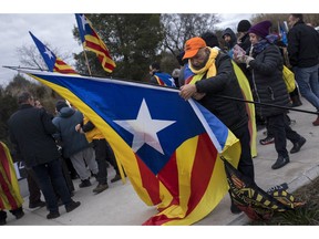 Demonstrators hold esteladas, or independence flags, as they gather in support of the imprisoned Catalan politicians outside the Brians II prison, in Barcelona, Spain, Friday, Feb.1, 2019. Spanish authorities transferred nine politicians and activists on Friday from prisons in Catalonia to the country's capital, Madrid, ahead of a high-stakes trial for their part in an attempt to secede from Spain.