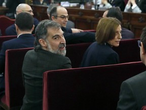 Jordi Cuixart, president of the Catalan Omnium Cultural organization, left, sits next to former Catalan Parliament speaker Carme Forcadell during the trial at the Spanish Supreme Court in Madrid, Tuesday, Feb. 12, 2019. Spain is bracing for the nation's most sensitive trial in four decades of democracy this week, with a dozen Catalan separatists facing charges including rebellion over a failed secession bid in 2017.