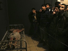 In this Jan. 7, 2019 photo, Iranian schoolboys look looks at an exhibition at a former prison run by the pre-revolution intelligence service, SAVAK, now a museum, where a wax mannequin of a prisoner is tied to a bed, in downtown Tehran, Iran. As Iran marks the 40th anniversary of its Islamic Revolution and the overthrow of the shah, those who suffered torture at the hands of the police and dreaded SAVAK still bear the scars. U.N. investigators and rights group say that even today, Iran tortures and arbitrarily detains prisoners.
