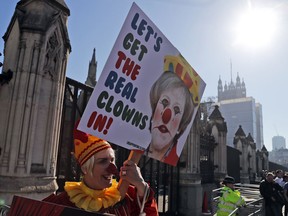 A Demonstrator protests at the entrance of the Houses of Parliament in London, Tuesday, Feb. 26, 2019. Bank of England Governor Mark Carney has warned that the Brexit uncertainty that has dogged the British economy over the past couple of years will remain even if lawmakers agree to a withdrawal agreement with the European Union in coming weeks.