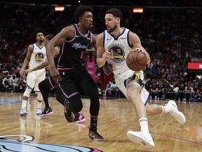 Golden State Warriors guard Klay Thompson (11) dribbles the ball against Miami Heat guard Josh Richardson (0) during the first half of an NBA basketball game Wednesday, Feb. 27, 2019, in Miami.