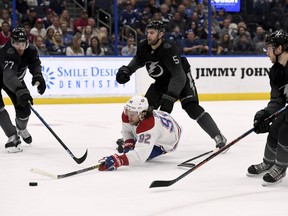 Montreal Canadiens left wing Jonathan Drouin (92) shoots after being tripped by Tampa Bay Lightning defenseman Dan Girardi (5) during the first period of an NHL hockey game Saturday, Feb. 16, 2019, in Tampa, Fla.