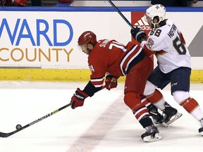 Carolina Hurricanes' Jaccob Slavin, left, and Florida Panthers' Mike Hoffman (68) compete for the puck during the first period of an NHL hockey game Thursday, Feb. 21, 2019, in Sunrise, Fla.