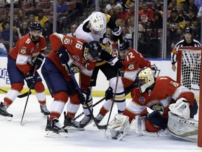 Florida Panthers goaltender Roberto Luongo (1) stops the puck on a shot by Pittsburgh Penguins center Nick Bjugstad (27) as center Aleksander Barkov (16) defends during the first period of an NHL hockey game, Thursday, Feb. 7, 2019, in Sunrise, Fla.