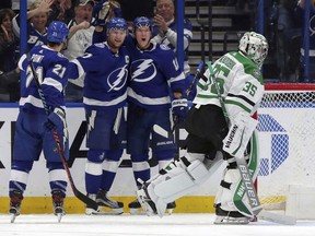 Dallas Stars goaltender Anton Khudobin, of Kazakhstan, reacts as members of the Tampa Bay Lightning, from left, Brayden Point, Steven Stamkos, and Ondrej Palat, of the Czech Republic, celebrate a goal during the first period of an NHL hockey game Thursday, Feb. 14, 2019, in Tampa, Fla.