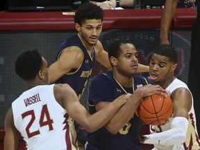 Florida State guards Devin Vassell (24) and MJ Walker, right, tie up Notre Dame guard D.J. Harvey (5) in the first half of an NCAA college basketball game in Tallahassee, Fla., Monday, Feb. 25, 2019.