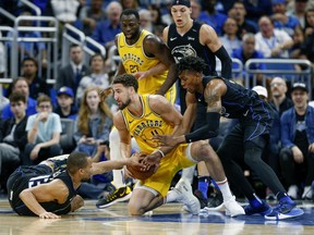 Orlando Magic guard Isaiah Briscoe (13) and forward Wesley Iwundu (25) fight for the loose ball with Golden State Warriors guard Klay Thompson (11) as Magic forward Aaron Gordon (00) and Warriors forward Draymond Green (23) look on during the second half of an NBA basketball game in Orlando, Fla., on Thursday, Feb. 28, 2019.