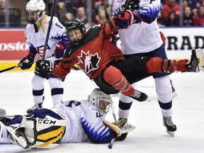 Canada forward Ann-Sophie Bettez (39) is pushed over United States goalie Katie Burt (41) after Canada scored during first period National Women's Team Rivalry Series hockey in Toronto on Thursday, February 14, 2019.