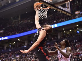 Toronto Raptors Marc Gasol makes a reverse dunk as Brooklyn Nets forward Ed Davis (17) looks on during second half NBA basketball action in Toronto on Monday, Feb. 11, 2019.