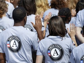 FILE- In this Sept. 12, 2014 file photo, as President Barack Obama and former President Bill Clinton mark the 20th anniversary of the AmeriCorps national service program, hundreds of new volunteers are sworn in for duty at a ceremony on the South Lawn of the White House in Washington. Hundreds of Teach for America alumni are slamming the educator placement program for telling members to cross the picket line during a potential teacher strike in Oakland, California, or risk losing thousands of dollars at the end of their service. In partnership with the AmeriCorps, Teach for America members can apply for an education award at the end of their service to help pay off student loans. An AmeriCorps spokeswoman couldn't immediately provide comment but said striking is prohibited.