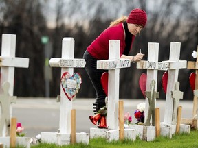 In this Feb. 8, 2019, photo, Tabatha Miller visits a memorial for Camp Fire victims in Paradise, Calif. Miller is helping rescue and re-settle animals displaced during the November 2018 blaze. In the 100 days since a wildfire nearly burned the town of Paradise off the map, the long recovery is just starting. Work crews have been cutting down trees and clearing burned-out lots, but Paradise is mostly a ghost town where survivors still dig for keepsakes in the foundations of their homes.