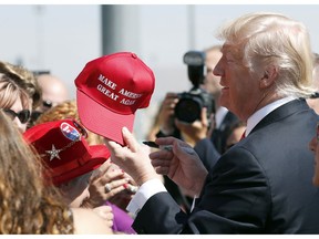 FILE- In this Aug. 23, 2017 file photo, President Donald Trump hands a signed "Make America Great Again," hat back to a supporter in Reno, Nev. An award-winning cookbook author and California restaurant owner says anyone wearing a red "Make America Great Again" baseball cap will be refused service at his restaurant. J. Kenji Lopez-Alt is a chef-partner of the Wursthall restaurant in San Mateo and says in a tweet Sunday, Jan. 27, 2019, that he views the hats as symbols of intolerance and hate.