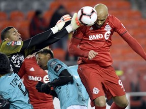 Toronto FC defender Gregory van der Wiel (9) fails to make the header as Club Atletico Independiente goalkeeper Jose Guerra (12) punches the ball away during second half Concacaf Champions League soccer action in Toronto on Tuesday, February 26, 2019.