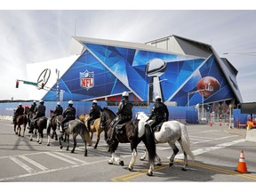 Police on horseback patrol past Mercedes-Benz Stadium ahead of Sunday's NFL Super Bowl 53 football game between the Los Angeles Rams and New England Patriots in Atlanta, Wednesday, Jan. 30, 2019.