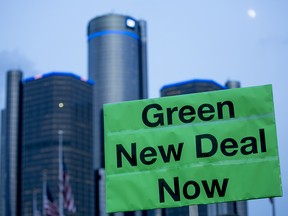 A demonstrator holds a sign supporting Congresswoman Alexandria Ocasio-Cortez's proposed Green New Deal at a United Auto Workers rally in Detroit, Mich., on Jan. 18, 2019.
