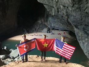 In this Monday, Feb. 15, 2019, drone image, cave explores pose with flags of North Korea, Vietnam and the U.S. in En cave in Quang Binh province, Vietnam. Vietnam will host the second summit between U.S. President Donald Trump and North Korean leader Kim Jong Un in Hanoi on Feb. 27-28. (Oxalis Adventure via AP)