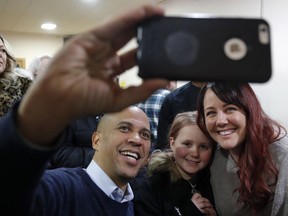 U.S. Sen. Cory Booker, D-N.J., poses for a photo with Alyssa Benson, of Mason City, Iowa, right, and her daughter Jersey, center, during a meet and greet with local residents at the First Congregational United Church of Christ, Friday, Feb. 8, 2019, in Mason City, Iowa.