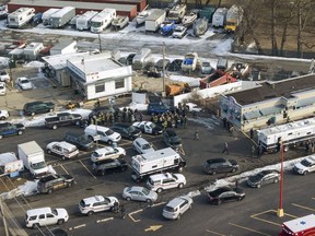 First responders and emergency vehicles are gathered near the scene of a shooting at an industrial park in Aurora, Ill.