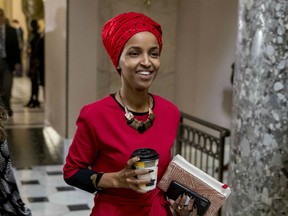 In this Jan. 16, 2019 file photo, Rep. Ilhan Omar, D-Minn., center, walks through the halls of the Capitol Building in Washington.