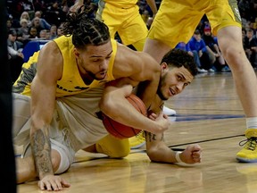 Marquette forward Theo John, left, fights for the ball against DePaul forward Jaylen Butz, right,  during the first half of an NCAA college basketball game on Tuesday, Feb. 12, 2019. in Chicago, Ill.