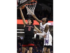 Rutgers guard Geo Baker, left, drives to the basket against Northwestern forward Vic Law during the first half of an NCAA college basketball game, Wednesday, Feb. 13, 2019, in Evanston, Ill.