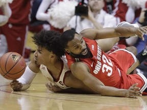 Indiana's Justin Smith, left, and Ohio State's Keyshawn Woods go for the ball during the first half of an NCAA college basketball game, Sunday, Feb. 10, 2019, in Bloomington, Ind.