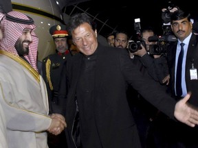 In this photo released by the Press Information Department, Pakistani Prime Minister Imran Khan, centre, greets Saudi Arabia's Crown Prince Mohammed bin Salman, left, upon his arrival at Nur Khan airbase in Rawalpindi, Pakistan, Sunday, Feb. 17, 2019.  Saudi Arabia's powerful Crown Prince Mohammed bin Salman began his four-day regional visit on Sunday, arriving in Pakistan where he is widely expected to sign agreements worth billions of dollars to help the Islamic nation overcome its financial crisis. (Press Information Department, via AP)