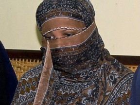 FILE - In this Nov. 20, 2010, file photo, Asia Bibi, a Pakistani Christian woman, listens to officials at a prison in Sheikhupura near Lahore, Pakistan. The Christian woman freed by Pakistan's Supreme Court which acquitted her on blasphemy charge was transferred to southern Karachi by Pakistan's security agencies, but has told a friend, who spoke to her on telephone, that she is being held in a room unable to leave and unable to find out when she can leave Pakistan. (AP Photo, File)