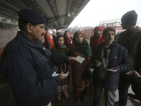 A Pakistani police officer checks documents of passengers travel to India via Samjhota Express at Lahore railway station in Pakistan, Thursday, Feb. 21, 2019.  Indian authorities suspended a bus service this week without explanation. The development comes amid escalated tensions between Pakistan and India in the wake of last week's deadly suicide bombing in Kashmir against Indian paramilitary troops.