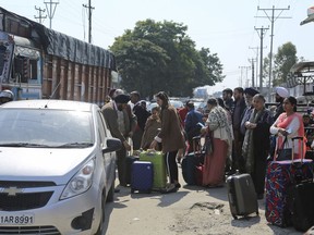 Stranded passengers stand outside an airport after it was closed for civilians operations amid tension along the border with Pakistan in Jammu, India, Wednesday, Feb. 27, 2019. Pakistan shot down two Indian warplanes Wednesday in the disputed region of Kashmir and captured their pilots, its military said, raising tensions between the nuclear-armed rivals to a level unseen in 20 years.