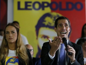 Venezuela's self-proclaimed interim president Juan Guaido, speaks during a news conference at the Voluntad Popular party headquarters, flanked by Lilian Tintori, the wife of opposition leader Leopoldo Lopez who is under house arrest, in Caracas, Venezuela, Monday, Feb. 18, 2019.